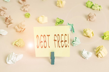 Writing note showing Debt Free. Business concept for does not owning any money or things to any individual or companies Colored crumpled papers empty reminder pink floor background clothespin