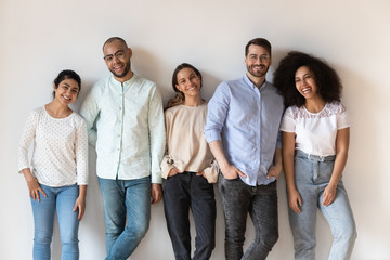 Portrait of smiling young diverse people standing in row