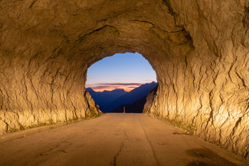 view of the Julian Alps after sunset from a rocky road tunnel