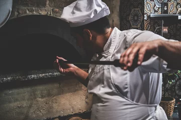 Gordijnen Tasty stonebaked pizza is ready and italian chef is removing it from oven. © Fxquadro