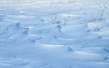 Fototapeta na wymiar Snow-white snow and the earth sheltered by it. Countryside and snowfall. Winter dunes and mountains of snowflakes. Stock background.