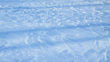 Obraz premium Snow-white snow and the earth sheltered by it. Countryside and snowfall. Winter dunes and mountains of snowflakes. Stock background.