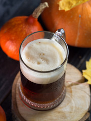 mug of pumpkin beer ale on the table with pumpkins and autumn leaves