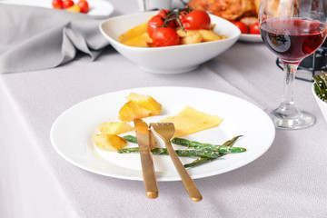 Plate with food on table set for big family dinner