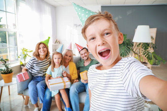 Little boy taking photo with his family during Birthday party at home