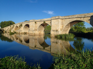 Fototapeta premium Reflection of Medieval Bridge over Pisuerga River near Itero del Castillo Spain