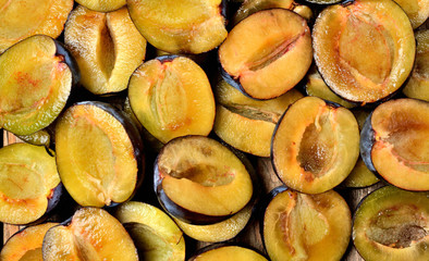 Half pieced fresh garden bio plums texture. Top view.