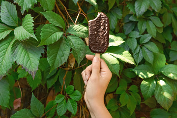 Female hand with tasty ice cream outdoors
