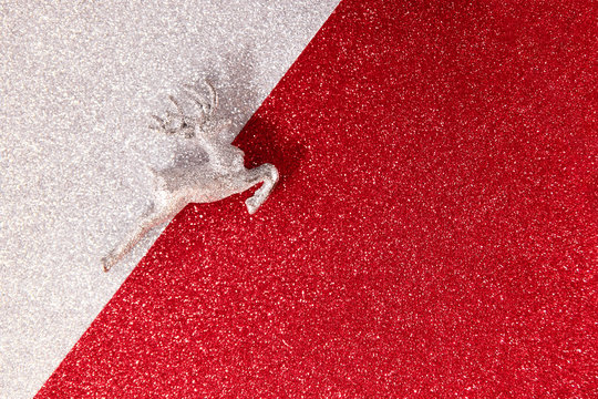 Christmas reindeer on silver and red glitter background, view from above with place for text.