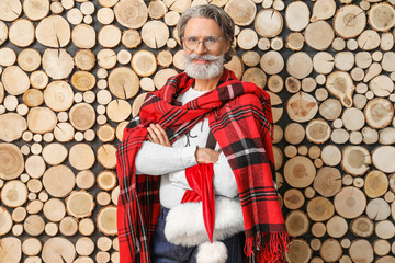 Portrait of stylish Santa Claus on wooden background