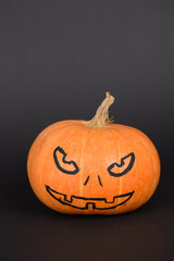 The orange pumpkin painted for Halloween on black background