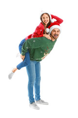 Happy young couple in Christmas clothes on white background