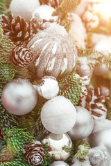 Silvery balls and cones with snow on a green Christmas tree. Winter background for greeting card