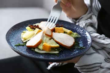 Woman eating tasty salad, closeup