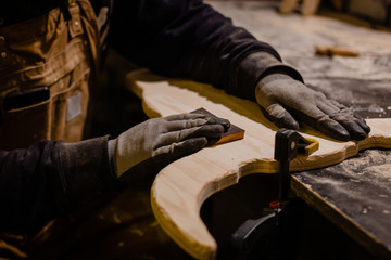 Carpenter polishing wood in workshop