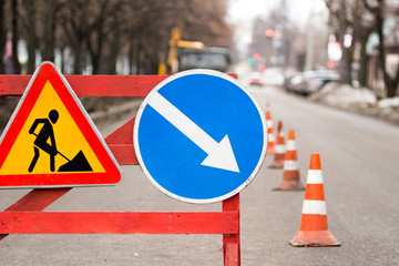 Road under construction traffic sign with a roadsign diversion on the right in the city.