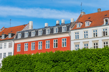 Scenic summer view of the ancient classic colorful houses with blue sky. Famous Nyhavn pier with colorful facades of old houses and vintage ships in Copenhagen, capital of Denmark