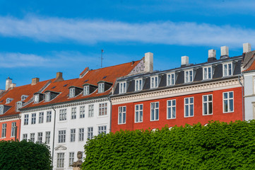 Scenic summer view of the ancient classic colorful houses with blue sky. Famous Nyhavn pier with colorful facades of old houses and vintage ships in Copenhagen, capital of Denmark