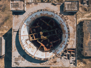 Aerial top down view of abandoned and ruined Nuclear Power Plant in Shelkino, Crimea. Large USSR industrial construction with round tower of atomic reactor, drone shot