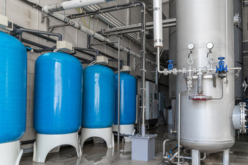 Drinking water factory or plant production, industrial interior. Large metal tanks for filtering...
