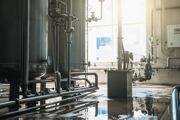Drinking water factory or plant production, industrial interior. Large metal tanks for filtering...