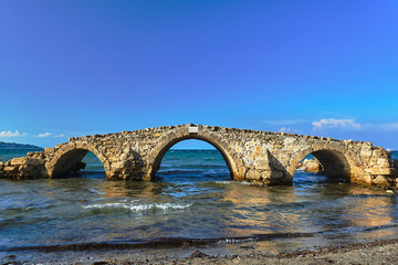 The ruins of a stone historic bridge on the coast of the island of Zakynthos in Greece..
