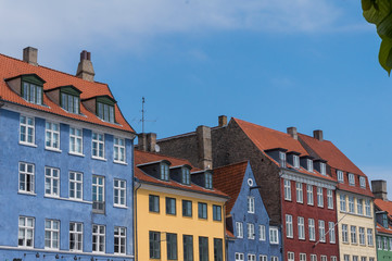 Fototapeta na wymiar Scenic summer view of the ancient classic colorful houses with blue sky. Famous Nyhavn pier with colorful facades of old houses and vintage ships in Copenhagen, capital of Denmark