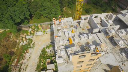 Aerial Building Process of Construction Site. Engineers crane and city.