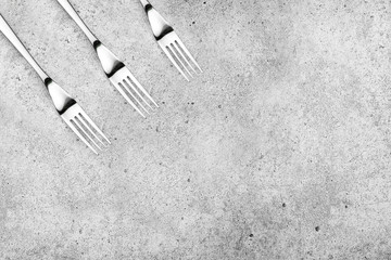 Cutlery. Forks on a light concrete background. Place for an inscription. Flat lay, top view, copy space.