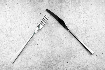 Cutlery. Forks and knives on a light concrete background. Flat lay, top view.