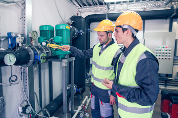 Workers checking parameters of pressure