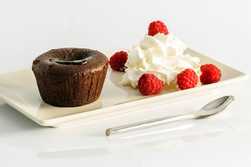 Dessert volkano of chocolate with cream and raspberry.