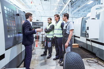 Manager and workers near CNC machines