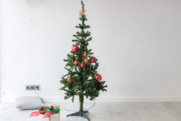 christmas tree in the room with ornaments for christmas coming