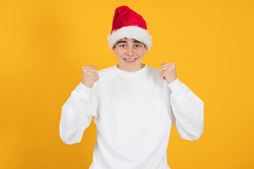 young teenage man with santa claus hat isolated on color background