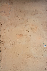 Concrete surface painted in light pastel colors with a rough texture.