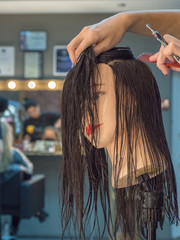 Naklejka premium Training hairdresser with mannequins. 