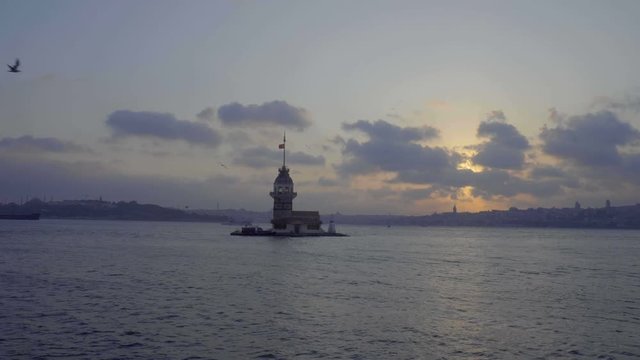 Historic Tower of Leandros lighthouse standing in bay of Uskudar as sun sets behind the clouds in evening 