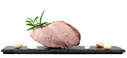 Baked piece of pork meat on black slate stone
