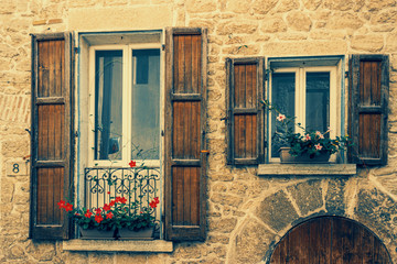 Picturesque facade of an ancient stone building with wooden shutters in San Marino