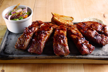 Typical Colombian dish, ribs with sauce, arepa, french fries and salad