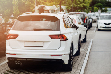 Cars in the parking lot.  White SUV car with sport and modern design, Back view of new white car.