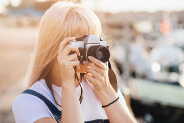 Close up Portrait of young beautiful girl photographer taking images with camera