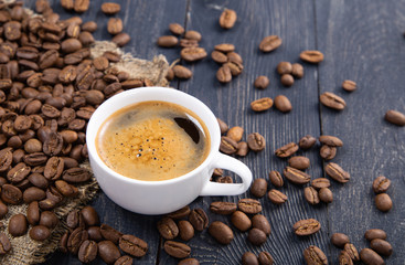 cup of coffee and beans on wooden table