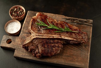 Grilled T-bone steak on a stone table. With rosemary and spices. 