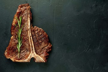  Grilled T-bone steak on a stone table. With copy space for your text.