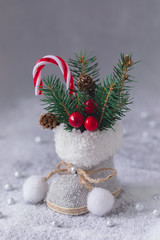 Little Christmas tweed retro boot with fir tree branches, cones and candy canes, postcard concept