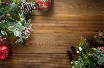 Christmas background, frme, border mock up. Pine cones, fir brances, red baubles on brown wooden table with copy space. Christmas flat lay.