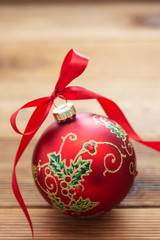 Christmas decoration beautiful red bauble with red ribbon cver wooden background. Copy space for text.