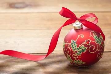 Christmas decoration beautiful red bauble with red ribbon cver wooden background. Copy space for...